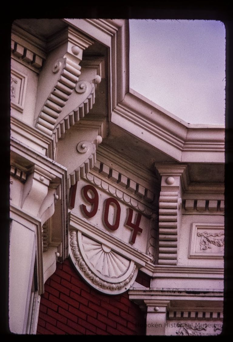 Color slide of detail view of cornice, brackets, dentils, bay windows and frieze reading 