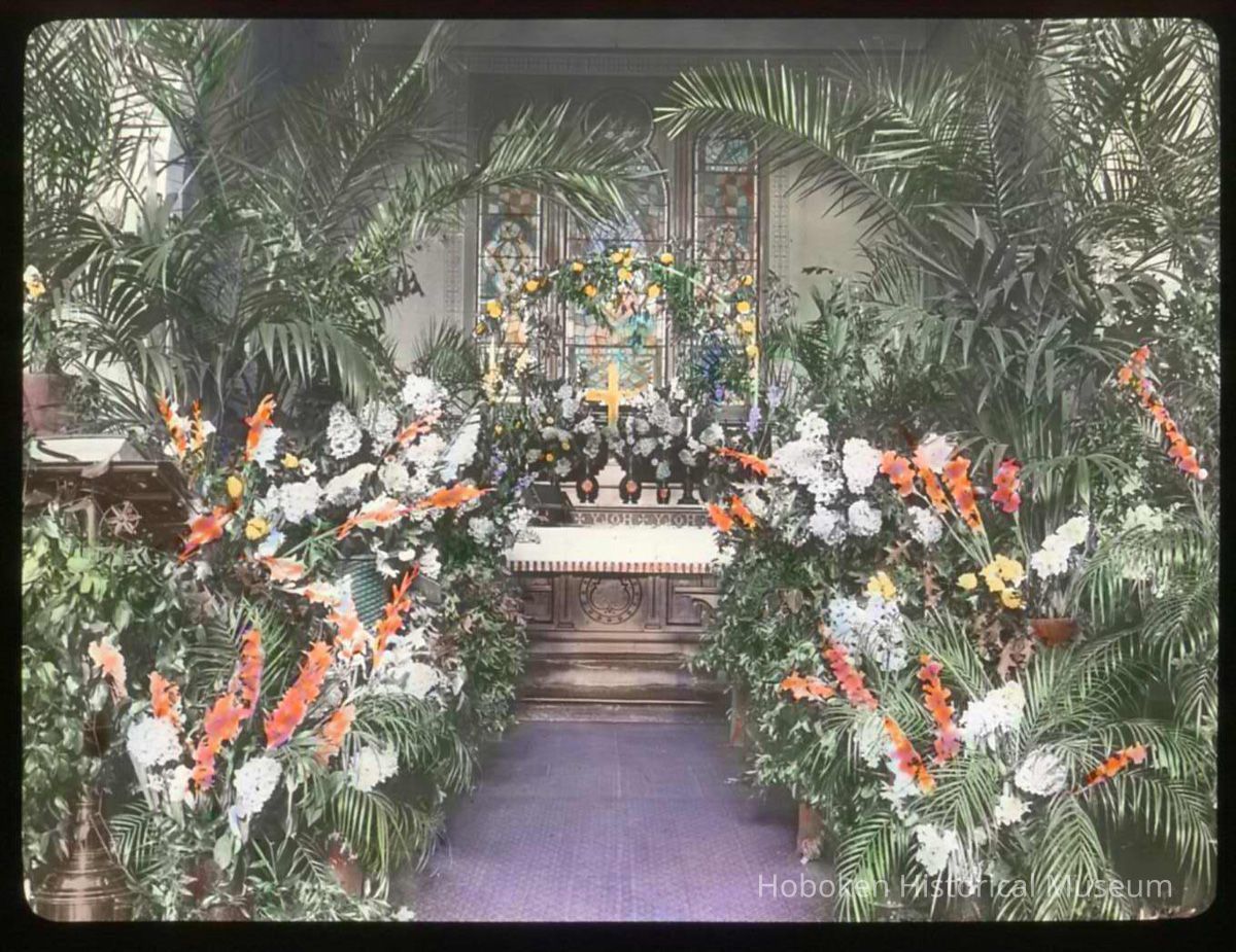 Lantern slide, color, of a church interior with floral decorations, used for promotional display in Hoboken, no date, ca. 1920. picture number 1