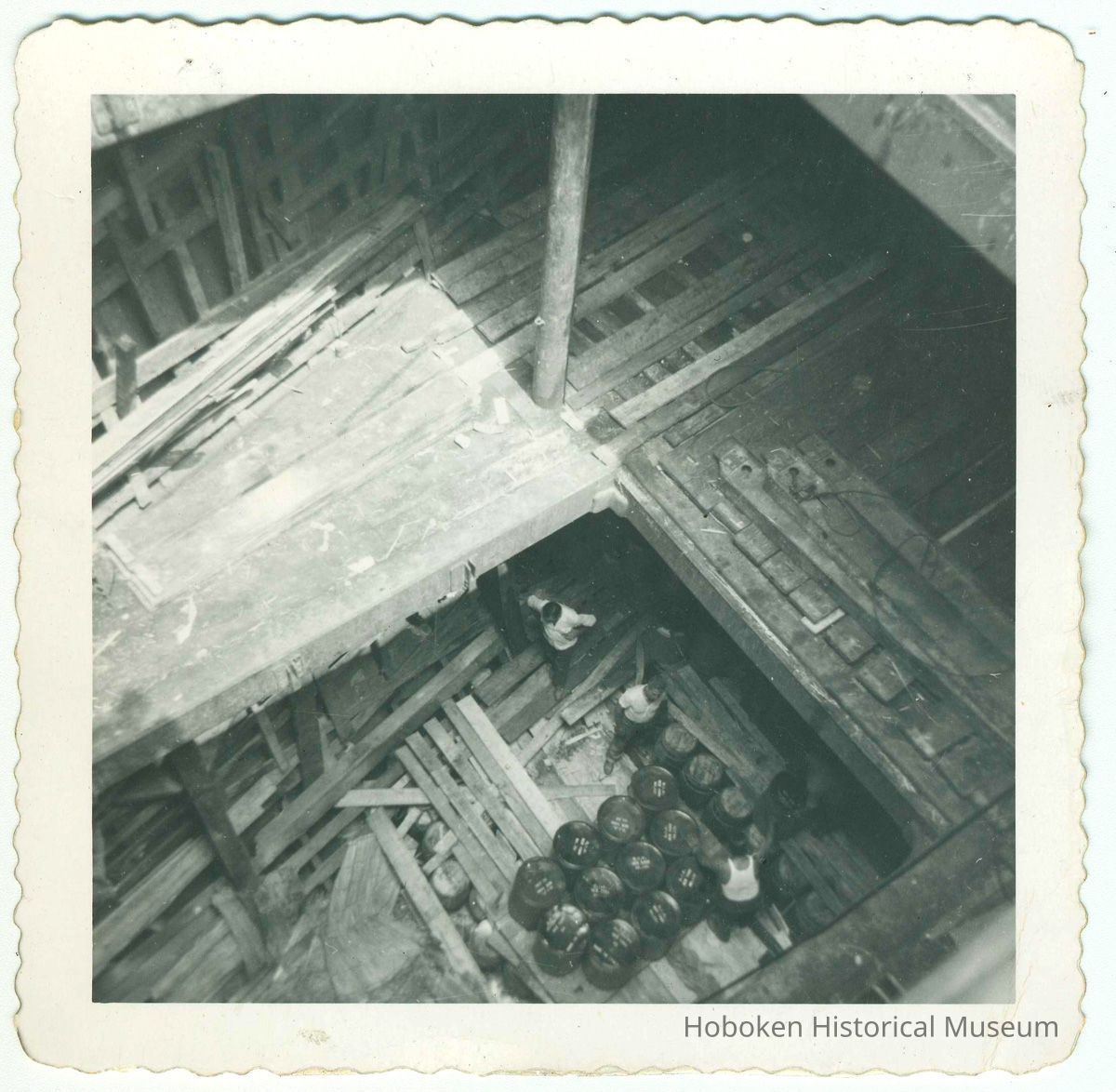 3 longshoremen at work in the cargo hold of an unidentified vessel