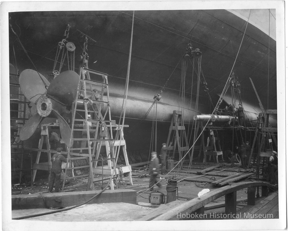 B+W photo of workmen doing propeller mounting on unknown ship in dry dock, Hoboken, no date, ca. 1940. picture number 1