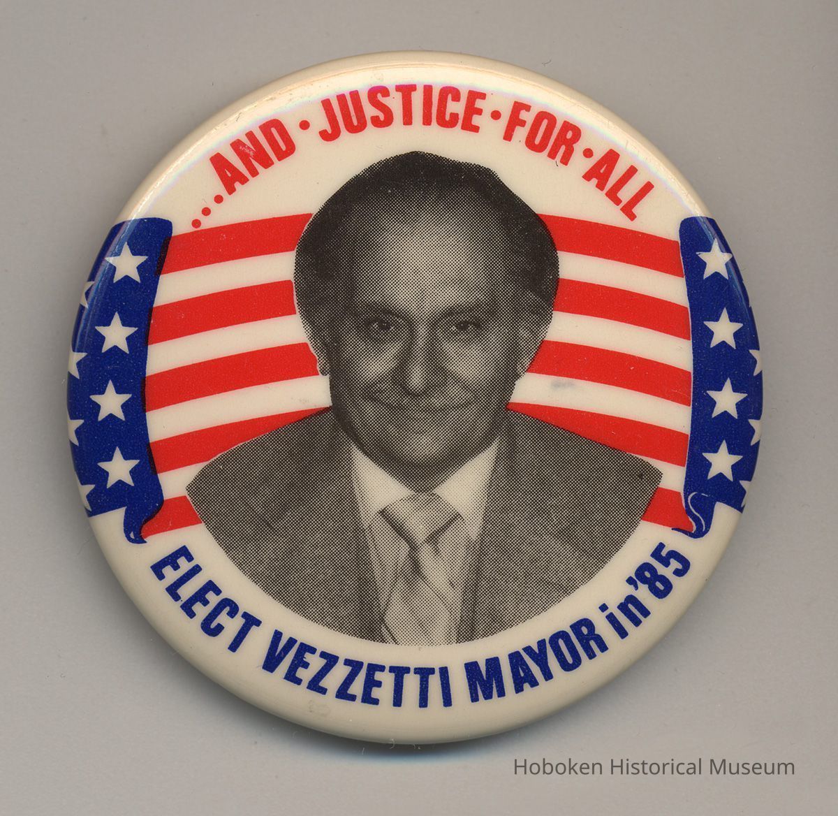 Political button: ...And Justice for All. Elect Vezzetti Mayor in '85.