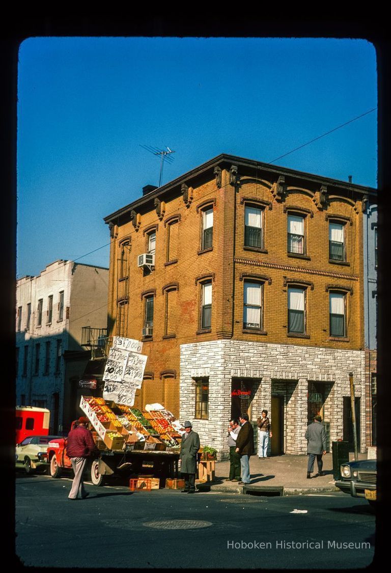 Color slide of eye-level view of street scene with a produce truck and an unidentified building on the corner of Washington and 5th picture number 1