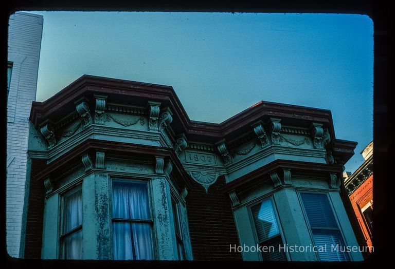 Color slide of close-up view of cornice, brackets, frieze reading 