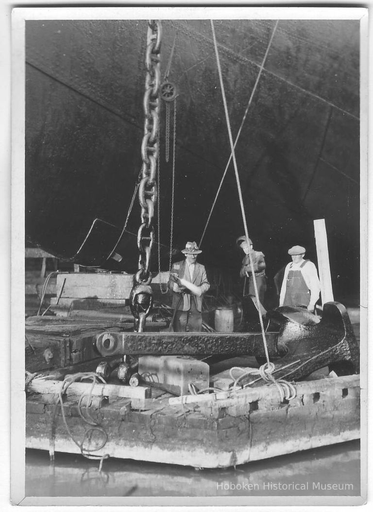 B+W photo of workers working on an anchor of an unknown ship in dry dock, Hoboken, no date, ca. 1940. picture number 1