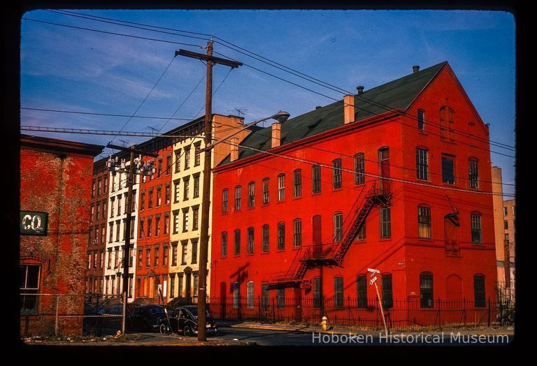 Color slide of eye-level view of industrial building façade with fire escape at 55 Bloomfield and adjacent four row houses along Bloomfield on the NE corner of Bloomfield and Observer Highway picture number 1