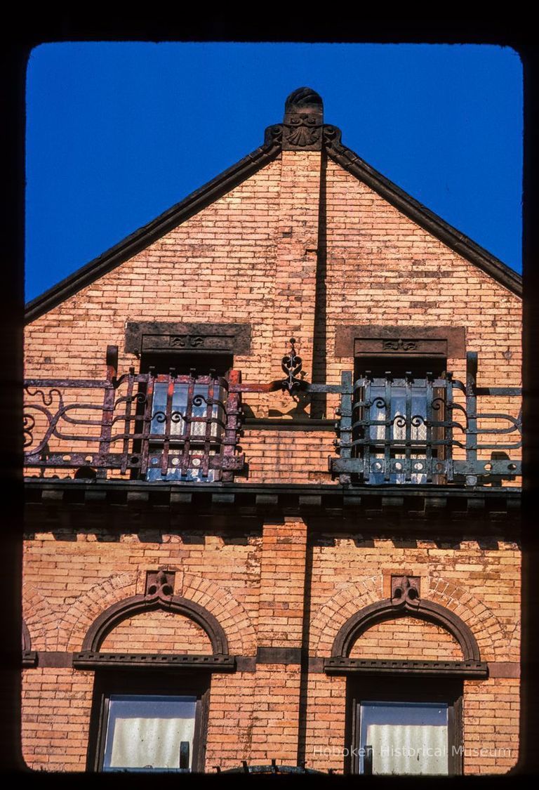 Color slide of close-up view of brick pediment, pilasters, semicircular arches, window heads and railings at 830 Hudson between 8th and 9th picture number 1