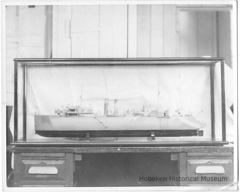 B+W photo of a ship model with camouflage design in a display case, Hoboken, no date, ca 1940-45. picture number 1