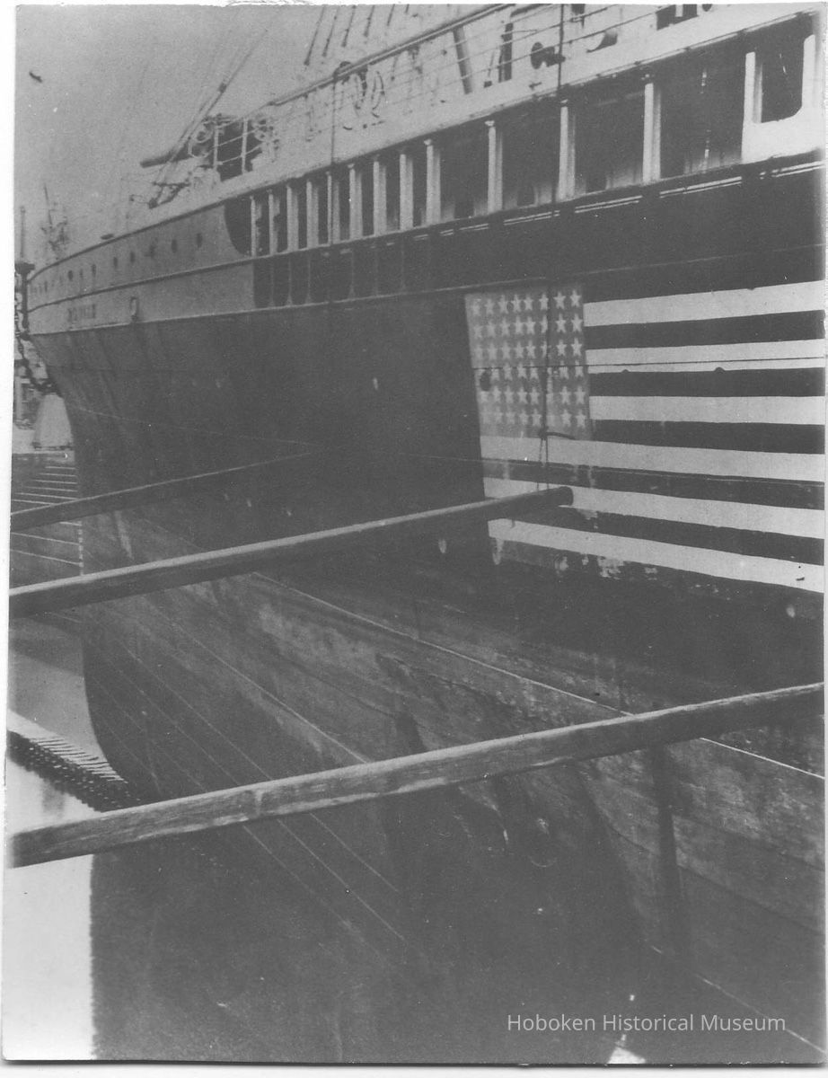B+W photo of an unknown ship in dry dock with a 48-star flag painted on its side, Hoboken, no date, ca. 1940. picture number 1