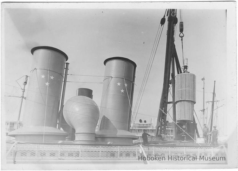 B+W photo of a crated engine part being loaded into or out of an unknown ship, Hoboken, no date, ca. 1940. picture number 1