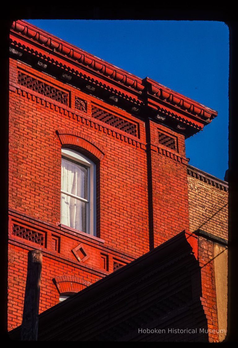 Color slide of detail view of cornice, dentils, brick friezes and arched window heads at 103 9th on the SW corner with Washington picture number 1