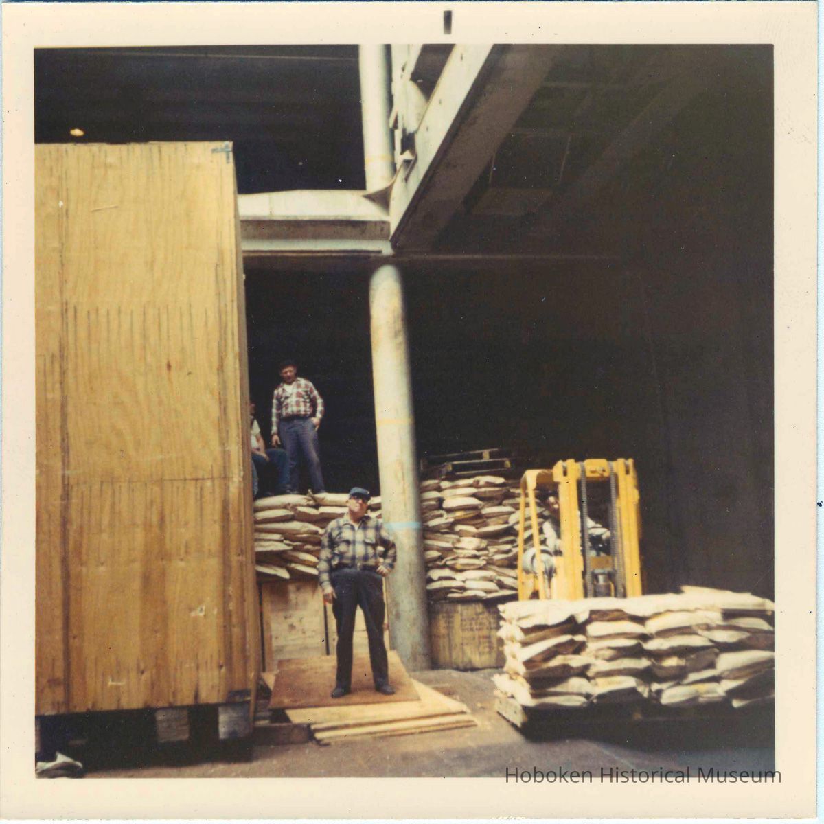 four longshoremen working with cargo in a pier shed