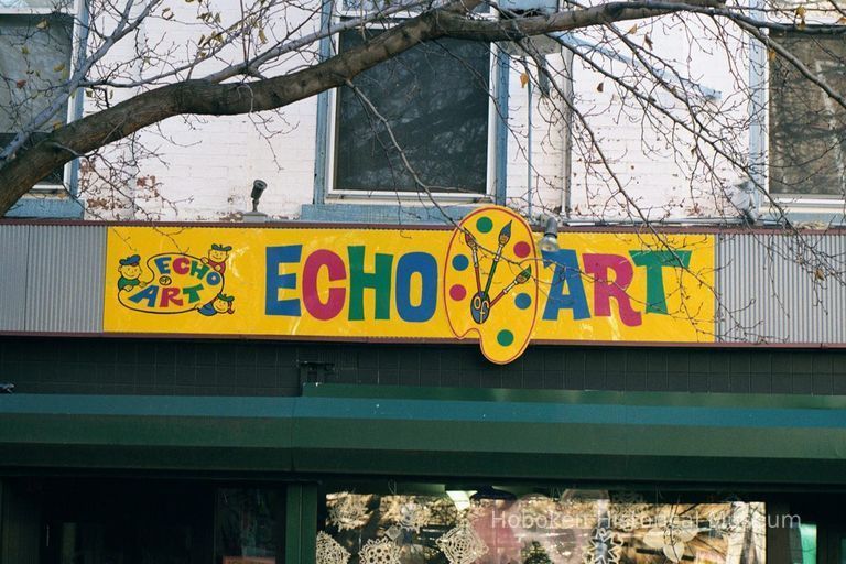 Color photo of hanging sign for Hoboken Furniture and wall sign for Echo Art, 157 First Street, Hoboken, Jan. 3 & 4, 2002. picture number 1