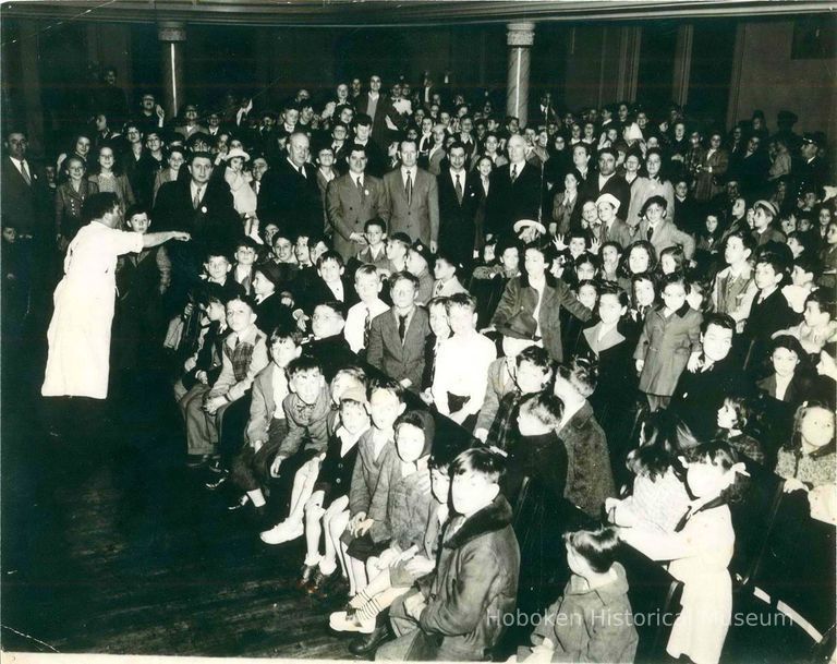 Color copy photo of a B&W photo of an assembly in a school auditorium, Hoboken, no date, ca. 1945-1950. picture number 1