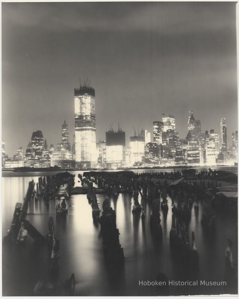 B+W photo of night view of World Trade Center towers under construction seen from Jersey City, n.d., ca. 1970. picture number 1