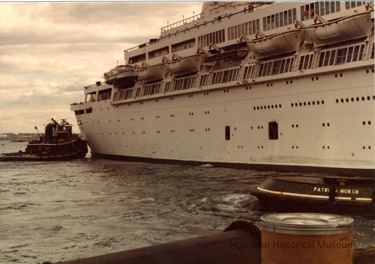 Digital scan of color photo of a passenger vessel with tugboat, location not given, no date, circa 1970-1980. picture number 1