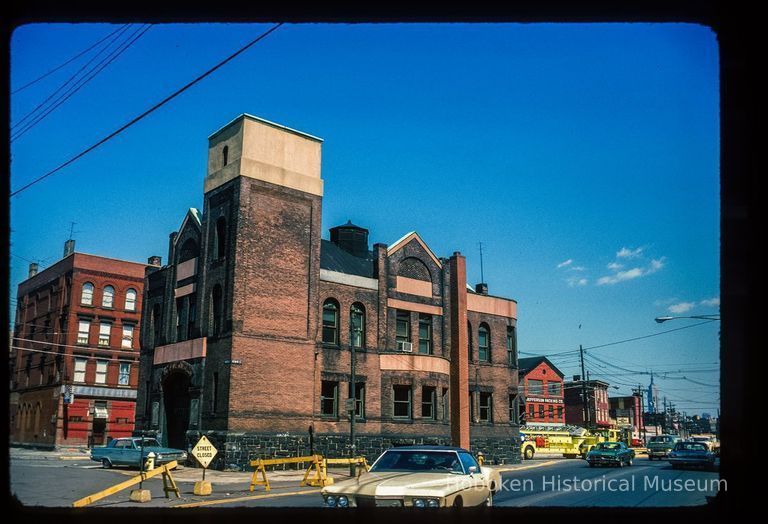 Color slide of eye-level view of the Hoboken Fire Department Engine Company No. 3 (Truck 2) fire station façade at 501 Observer Highway looking E at the juncture with Newark and showing the Jefferson Packing Co. on the corner of Jefferson and Newark picture number 1