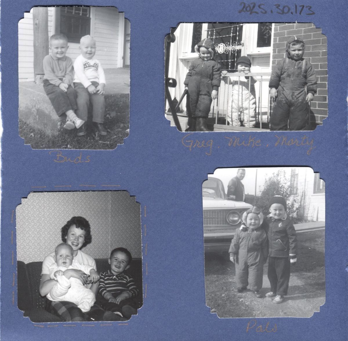 Photos retrieved from the Wade family photo album that are stuck to the page.: The image is a collage of four black-and-white photographs featuring children in various poses with handwritten captions such as "Buds," "Greg, Mike, Marty," and "Pals," displayed against a blue background with orange pen captioning the photos. In the bottom left is a photo of a young boy sat next to his mom who's holding a baby.