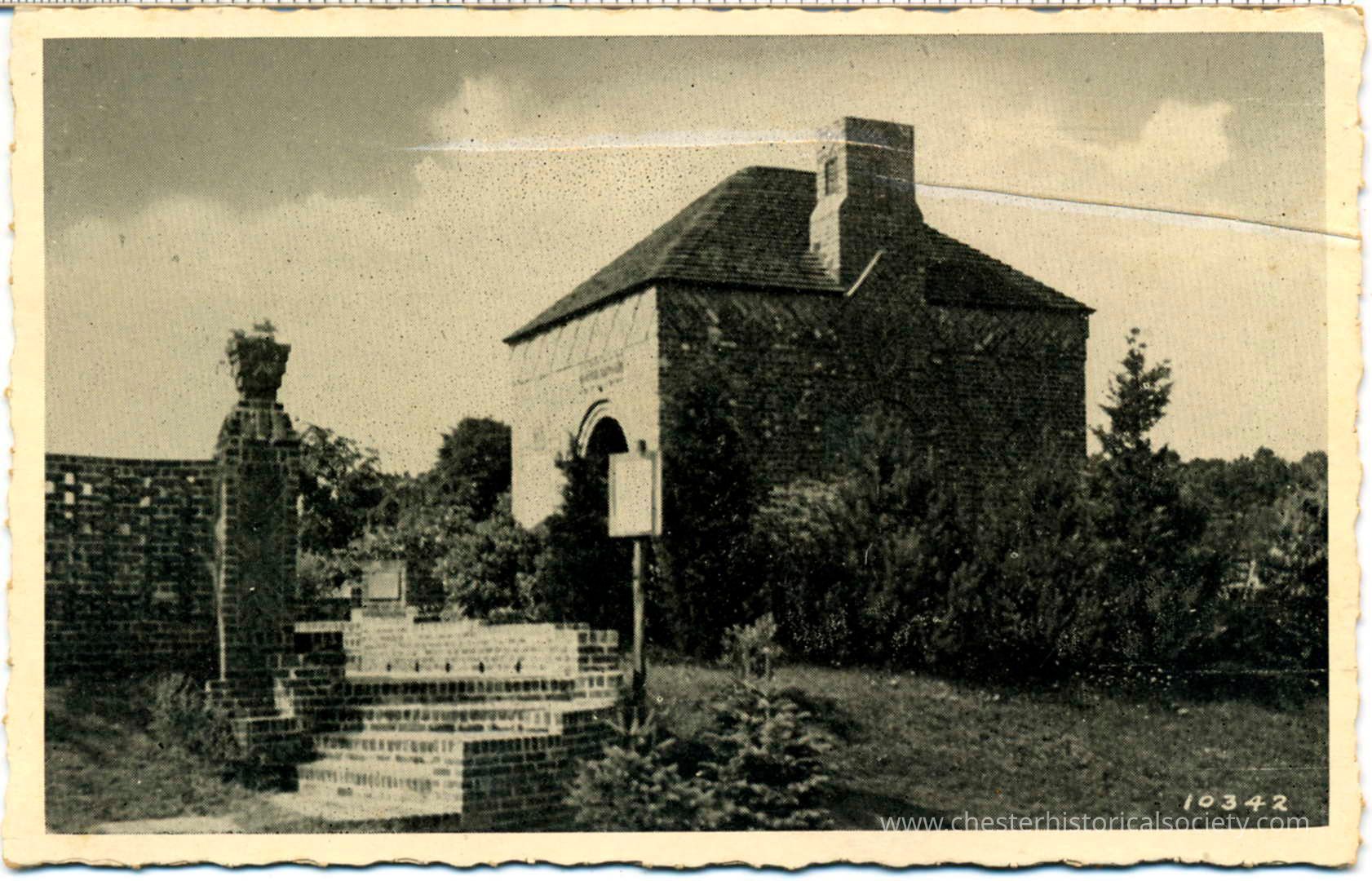 Tea House in Dutch Garden, New City, N. Y.: The image depicts a vintage black and white postcard showing a small stone building with a chimney, surrounded by lush greenery and a few small trees, with a brick wall and statue on the left side, all set under a cloudy sky, giving a timeless and serene countryside atmosphere; the building features an arched doorway and appears to be made of stone bricks, conveying a sense of historical charm and rustic elegance; the postcard's edges are slightly worn, adding to its antique feel, and a number, “10342."