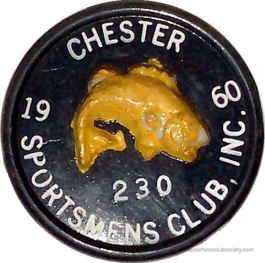 1960 Chester Sportsmen Club pin #230: The image shows a circular plastic badge from "Chester Sportsmens Club, Inc." with a black background and white lettering. In the center, there is a raised, yellow fish design. The numbers "230" appear below the fish, and "19" and "60" are on either side, indicating the date. The badge likely represents membership or association with the club.