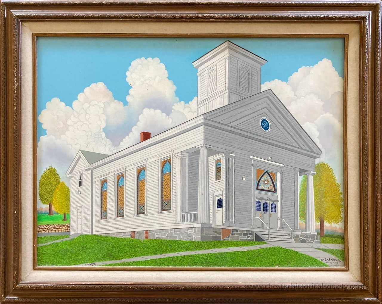 Methodist Church of Chester: The painting depicts the white Methodist Church of Chester with neoclassical architecture, featuring tall columns supporting a portico and a steeple rising above. Stained glass windows on the side add vibrant color to the structure. The church is situated on a lush green lawn with a path leading to the entrance, and it is framed by light green and yellow trees. The background sky is a vivid blue filled with large, fluffy white clouds that enhance the serene setting. The scene is encapsulated in a decorative brown wooden frame.