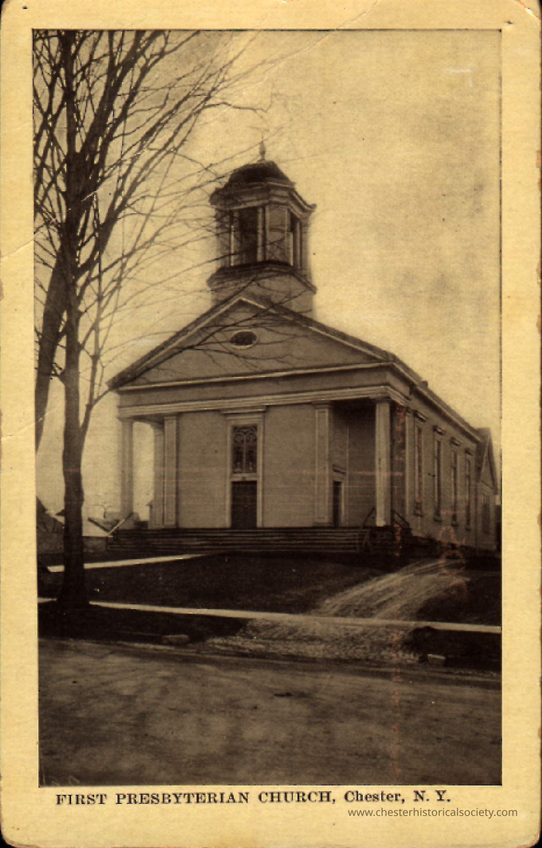 First Presbyterian Church, Church, New York: This monochrome photo postcard depicts the First Presbyterian Church located in Chester, New York, featuring a classic Greek revival architectural style with a prominent ell tower and a front entrance flanked by large columns. Leafless trees and a clear sky frame the building, with the church's name and location inscribed at the bottom.