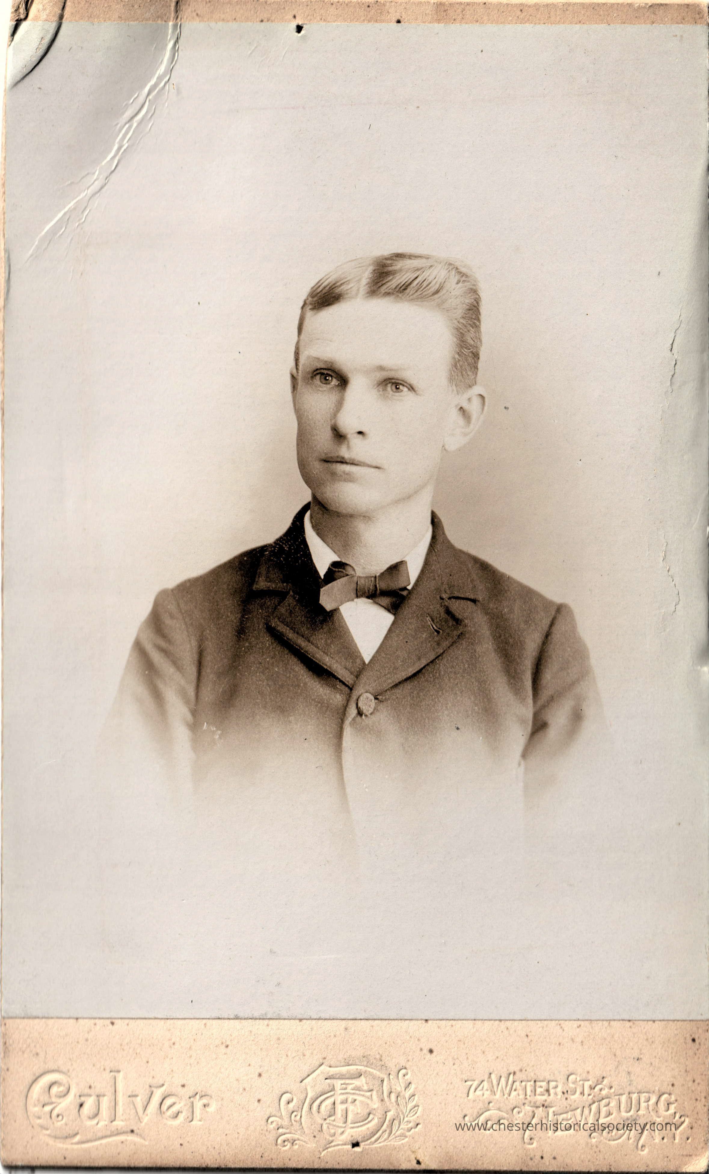 Charles W. Kerner: This is a vintage studio portrait of Charles W. Kerner, Chester, N.Y. on August 10, 1896 as a clean-shaven young man with neatly combed hair and intense gaze, dressed in a formal dark suit with a bow tie. The photograph shows some signs of wear and tear, including visible creases. Notably, the bottom of the image features the embossed name and address of the photographer, "Culver, 74 Water St., Newburgh, N.Y.