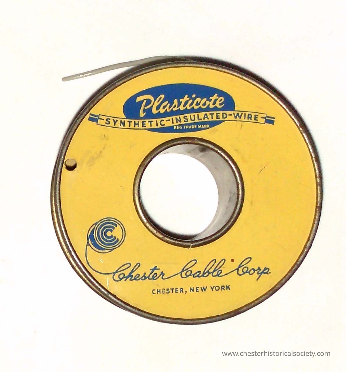 Insulated Wire Spool. Chester Cable Corp. - Side A: The image displays a circular spool labeled "Plasticote Synthetic-Insulated-Wire" in blue text atop a yellow background, with "Chester Cable Corp." written in script, indicating it originates from Chester, New York; the spool is partially used, revealing some of the gray wire coiled around it, while the colors and design reflect a classic or vintage appearance, the product is from mid-20th century.