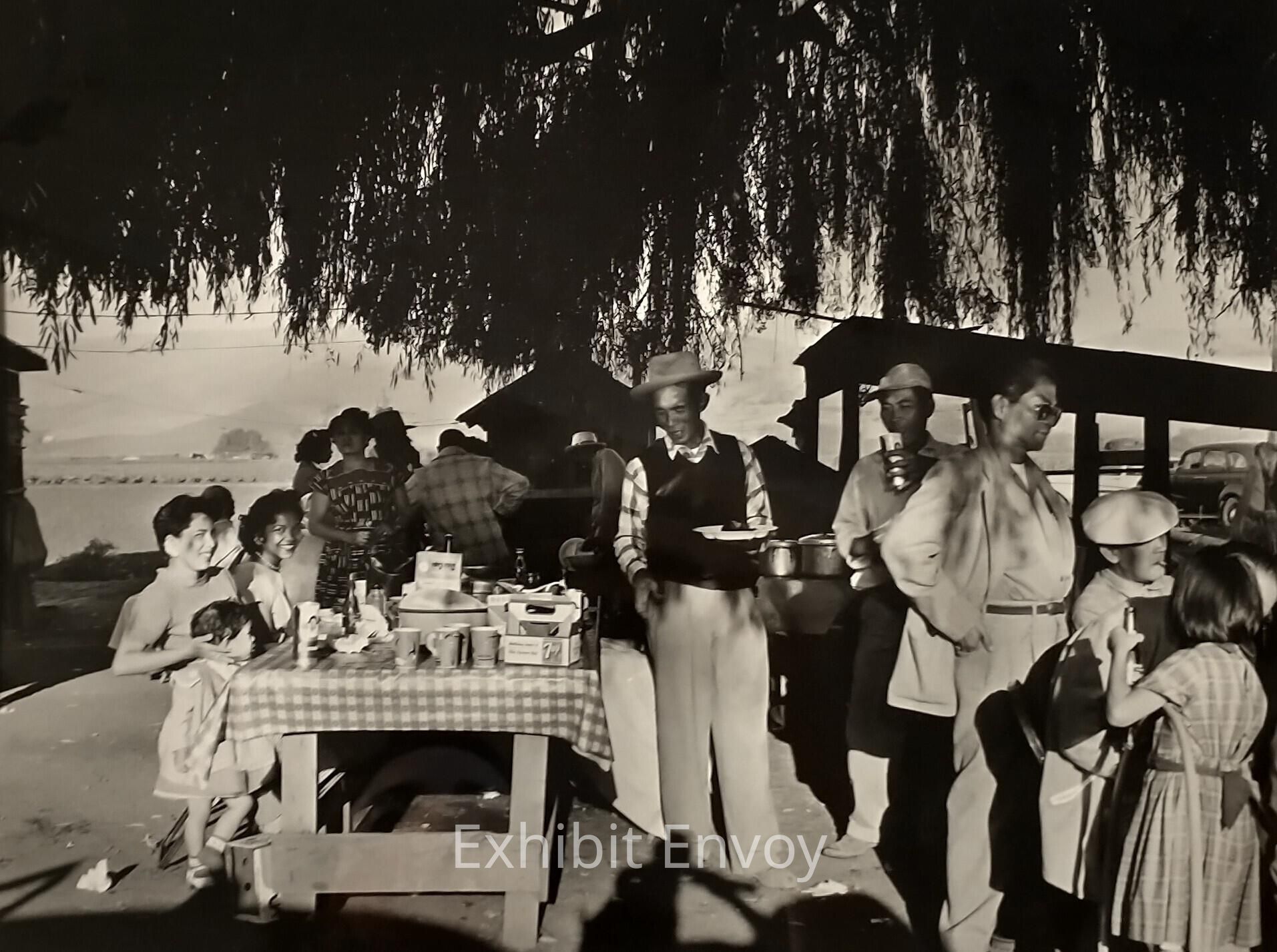 Filipino families and friends from the city often visited their "Manongs" and "Uncles" in the countryside on weekends. Ricardo Alvarado took this photograph during a visit to his eldest brother, Cirilo, a Manong migrant farmworker. During visits, the families feasted, played cards, and caught up on each other's news.