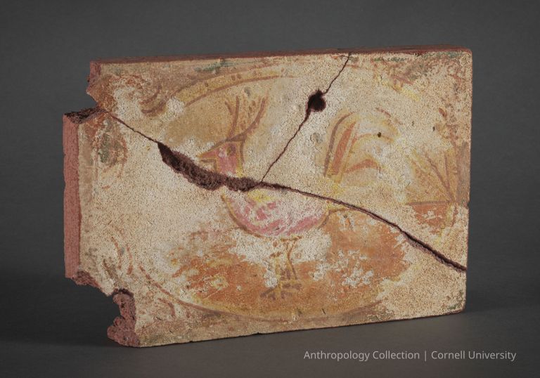 FRAGMENT OF A MURAL | circa 1967-71 | Photo by Ann Cady, 2024 | ©2026 Norman Daly Art — An ancient, cracked and fragmented fresco depicting a faded red  bird surrounded by ornamental patterns. The fresco's visible deterioration contributes to its archaeological significance, suggesting its long passage through time and hinting at the richness of the culture which created it.