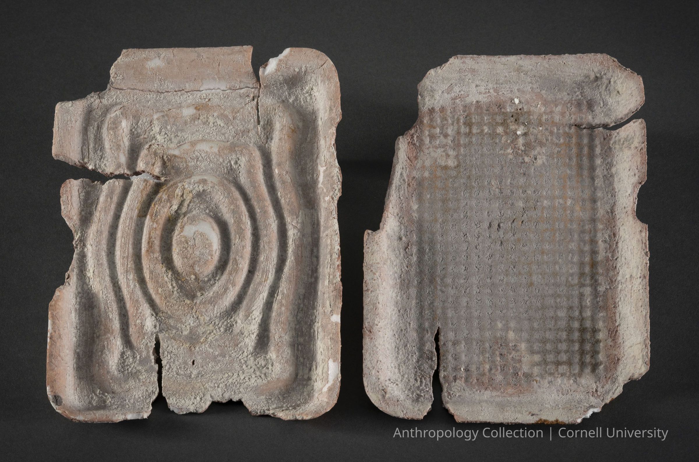 MARINATING TRAYS | 1966-71 | Photo by Ann Cady, 2024 | ©2026 Norman Daly Art: The photo depicts two ancient, weathered trays with distinct patterns; the left mold features concentric oval and circular designs with significant erosion and cracks, while the right mold has a grid-like texture with similar wear, each displaying unique texture and erosion patterns, and set against a dark, neutral background that highlights their intricate details and aged, rough surfaces, evoking a sense of a bygone era.