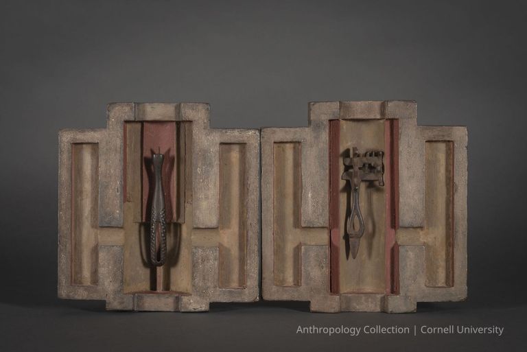 HOME VOTIVE SHRINE IN TWO PARTS | circa 1966-71 Photo by Ann Cady, 2024 | ©2026 Norman Daly Art — A diptych consisting of two symmetrical wooden panels with angular, geometric cutaways, with a mix of earthy beige, brown, and faint reddish hues. Each panel has a central compartment containing a unique metal object.