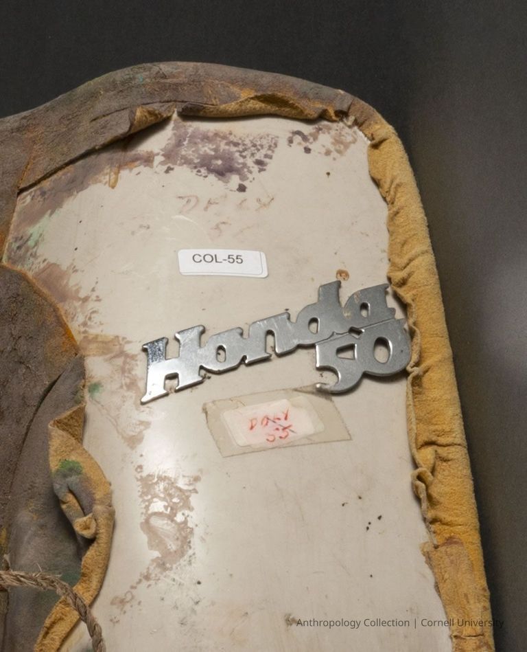Close up of emblem shown on the front of the gas tank cover of the Honda 50 Elite scooter. This was not seen by the public because it was on the back of the mask. :) The image displays a shiny metal emblem with raised letters spelling "Honda 50" on a plastic surface.