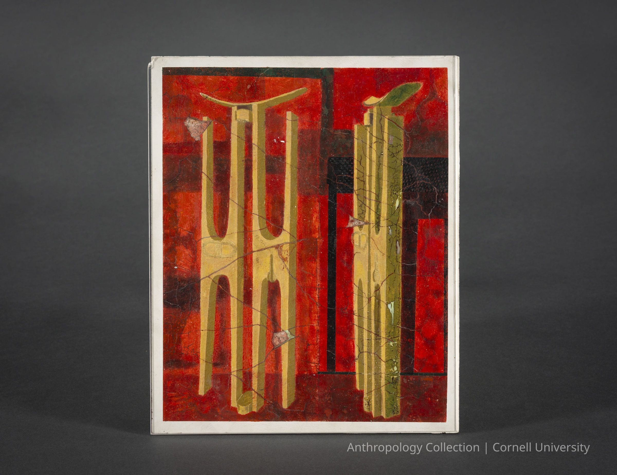 FACSIMILE OF A WALL PAINTING AT THE TEMPLE OF UOYAB DEPICTING A RITE | 1966-71 | Photo by Ann Cady, 2024 | ©2026 Norman Daly Art: The 9 x 11-inch facsimile shows two sets of tall, angular golden figures, each joined at the inner 'feet' and sharing a top arc, positioned within an atmosphere of warm, vivid red hues Thought to be a representation of pairs of Llhuroscian stilt-walkers, they are intersected with patches of black and traces of earthy tones, creating a layered, textured effect.