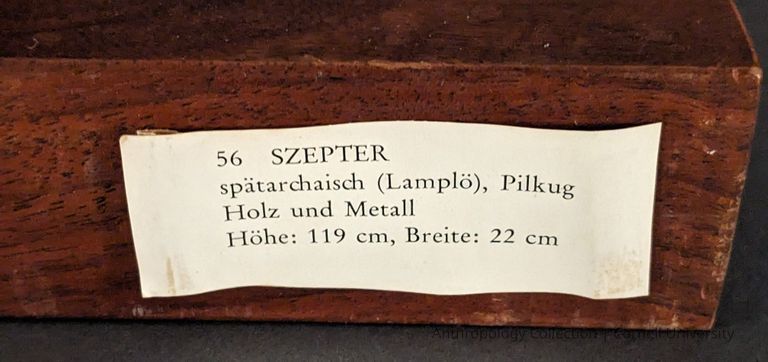 MUSEUM TAG from Romische-Germanisches Museum | "Projekt '74" | Cologne, 1974 — Label on the wooden base reads in German "56 SZEPTER, spätarchaisch (Lamplö), Pilkug, Holz und Metall, Höhe: 119 cm, Breite: 22 cm.