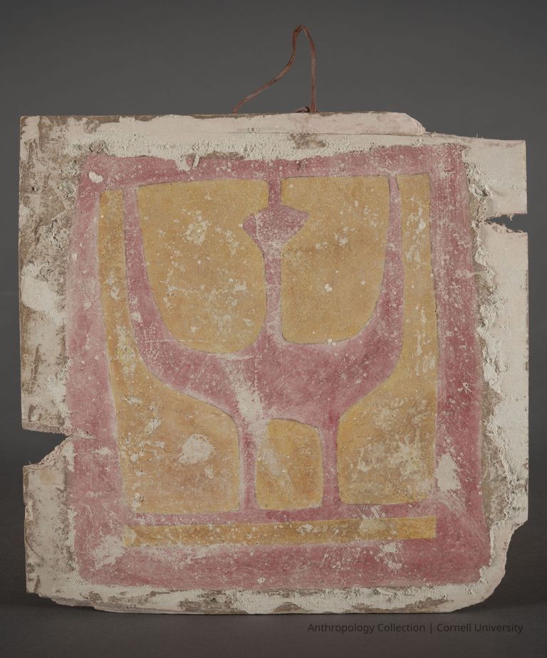 METOPE FROM TEMPLE DEDICATED TO AAR-TENN | circa 1967-71 | Photo by Ann Cady, 2024 | ©2026 Norman Daly Art — A square, weathered image of a faded red bird with raised wings There is a gold-colored background with a faded red border. Visible areas of wear convey a sense of antiquity. The artifact is hung by a twine hook.