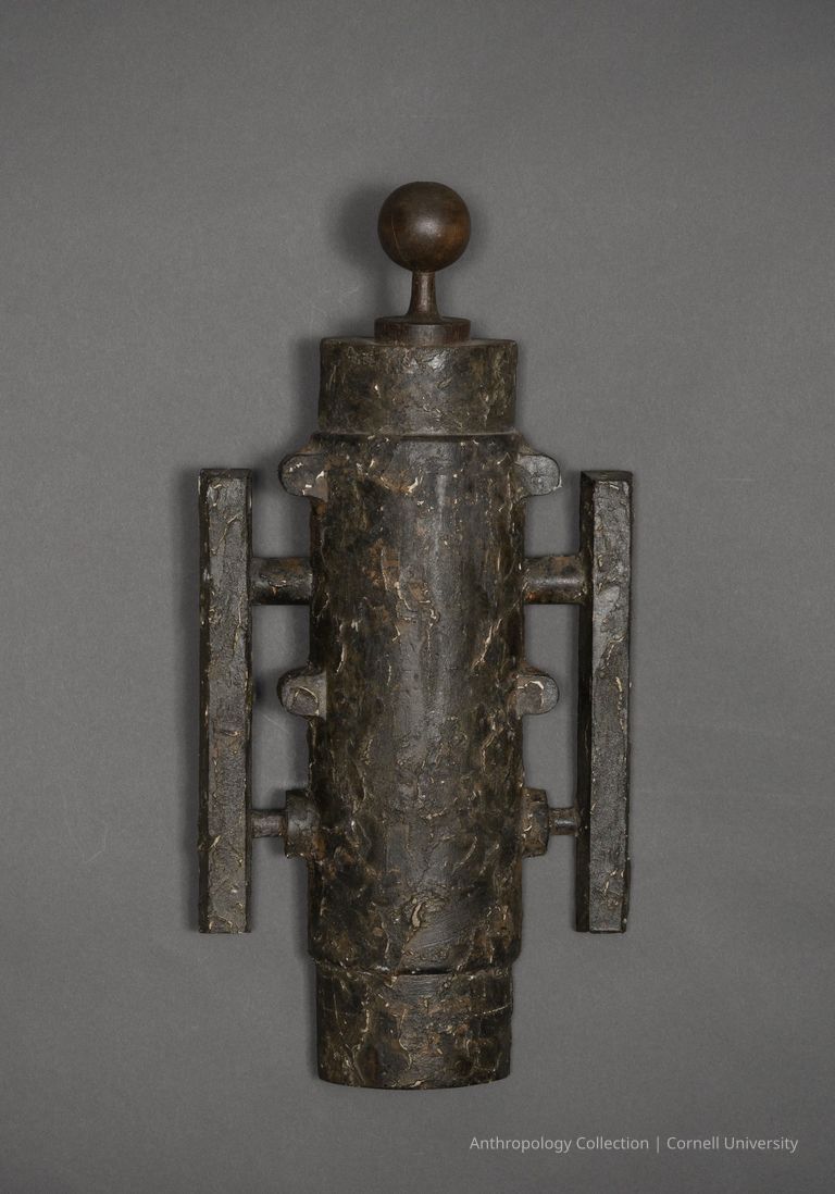 SMALL MACE | 1966-71 | Photo by Ann Cady, 2024 | ©2026 Norman Daly Art — A dark, weathered, cylindrical wood object with a black rustic finish, having a smooth wooden knob on top and two horizontal, similarly-textured, rectangular wood handles flanking its sides, creating a symmetric and robust appearance.