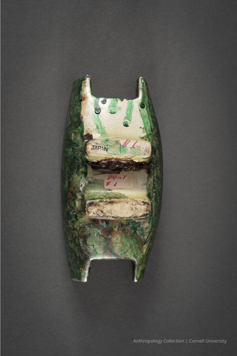 Back/bottom view of "Unidentified" vessel | Photo by Ann Cady, 2024 | ©2026 Norman Daly Art — This view of the object shows handwritten labels, including "JAPAN," and markings in red and black ink suggesting the original object was an import from Japan which  Norman Daly altered to resemble an ancient Llhuroscian artifact. Note: this view is never shown in exhibition in keeping with the ruse.