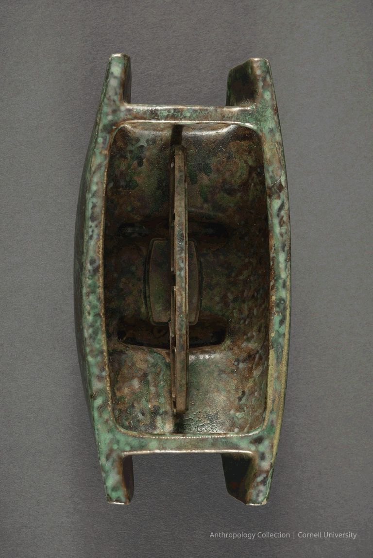 UNIDENTIFIED | circa 1966-71 | Photo by Ann Cady, 2024 | ©2026 Norman Daly Art — The photo features an ancient oblong bronze vessel with a verdigris patina, standing on four sturdy legs, characterized by its minimalist yet functional design, likely used in Llhuroscian ritualistic or ceremonial practices; its surface shows aging and use, reflecting its historical and archaeological significance.