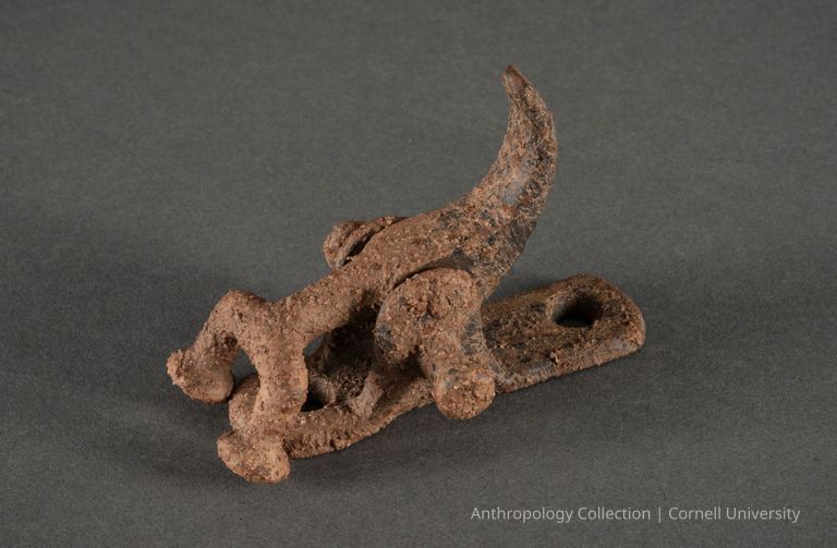 PAIR OF SODOMITES, MINOR OFFICIALS | circa 1966-71 | Photo by Ann Cady, 2024 | ©2026 Cornell University — The image shows two rusty, ancient interlocking figures, set against a dark grey background that highlights its corroded texture and intriguing form.