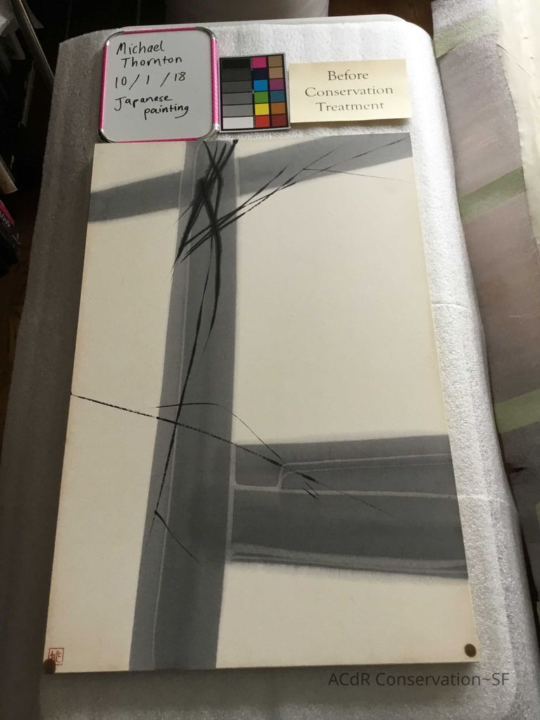 Before treatment - dirty edges and two circular areas of discoloration present at bottom two corners, likely due to rusty nails in the wooden stretcher the paper is adhered to. These marks are also present along top edge on turn over. 