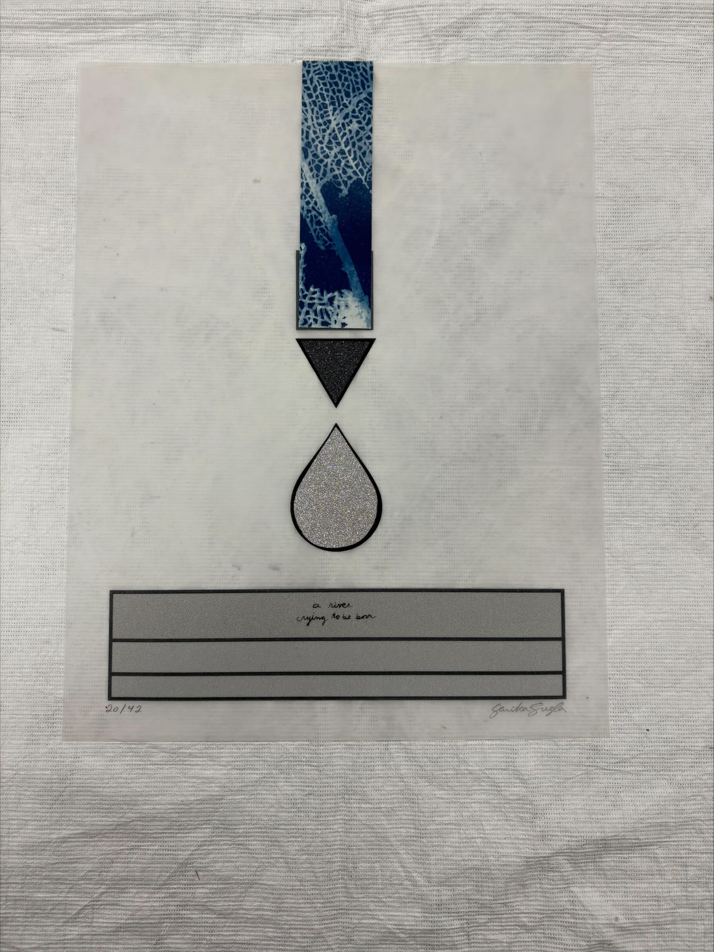Front: A vertically oriented, medium sized cyanotype and laser print that uses the colors blue, grey and black. The print uses geometric shapes such as rectangles and triangles to imitate a tear drop and a river.