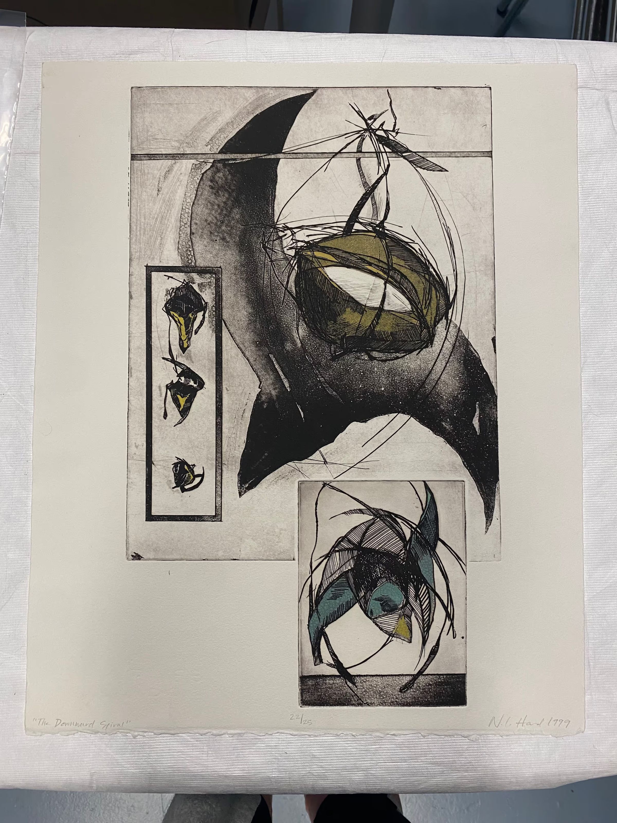 The Downward Spiral: Large vertically oriented multi-plate intaglio print of abstract shapes in motion in space. The larger plate has a large central dark shape and a hanging object from a line that stretches horizontally across the top region. On the right is a vertical rectangle with three smaller shapes stacked one above another, going from smallest to largest. The smaller plate in the bottom region has a similar shape with green and blue pigment that mirrors the large dark central shape in the first plate. Lines are added around both shapes in each plate to emphasize an element of motion, falling and spinning.
