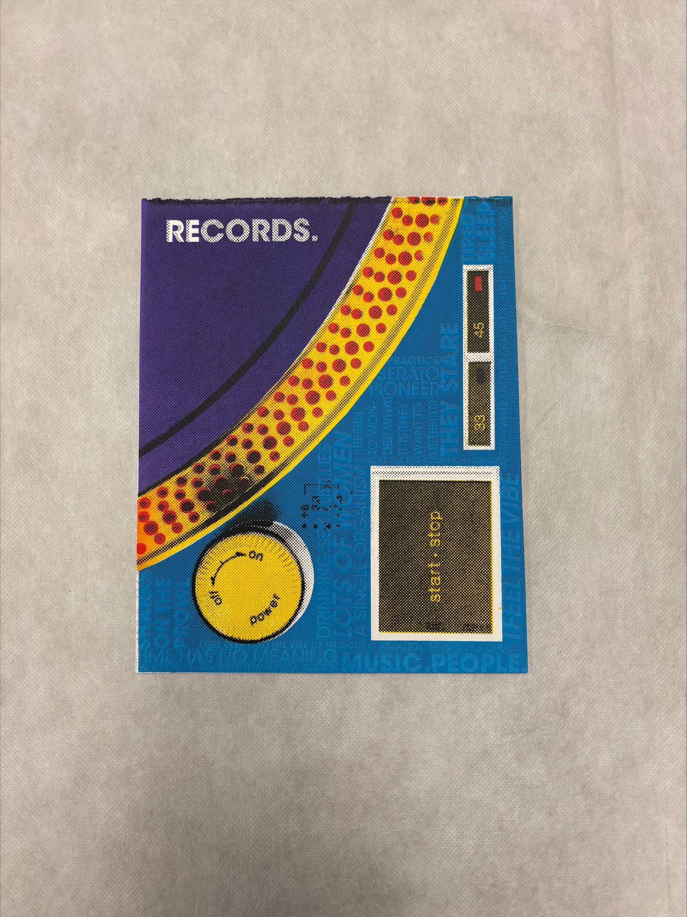 Front: A vertically oriented, medium size print that utilizes tones of yellow, red, purple, blue, black and white to create the imagery and text for this print. This print depicts a cropped perspective of a recored table with light blue text on top of the table using language often associated with the night life/clubbing.