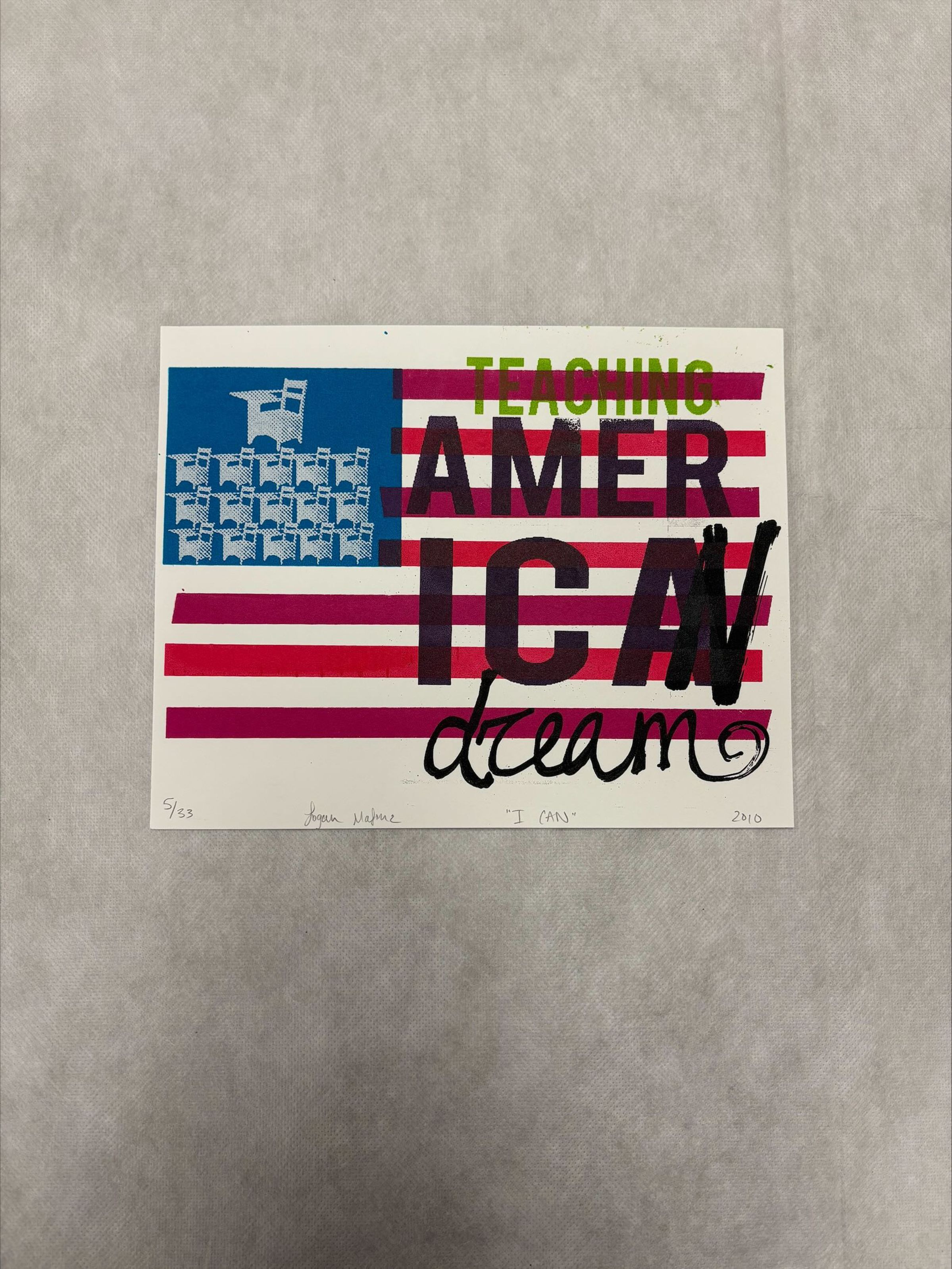 Front: A horizontally oriented, medium sized print that has a mix of imagery and text, with red, black, magenta, white , blue and green. The print is an artistic rendering of the American flag with chairs in place of the stars on the corner with text overlapping on the stripes of the flag.