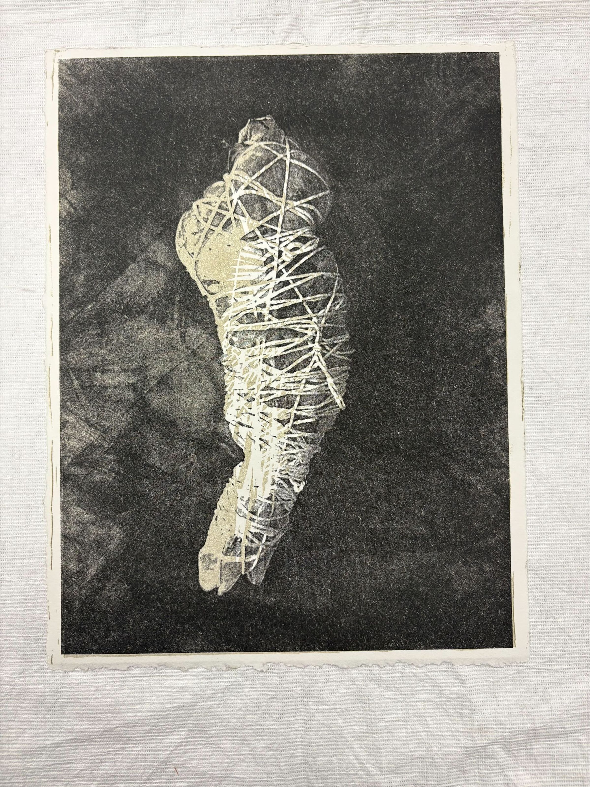 Front: A vertical oriented, standard letter size risograph, woodcut, screen print done in black and white, The print depicts what is hinted to be a body bag tied with rope on the front, and on the back there is the outline of the bag with text in the center on a black background.