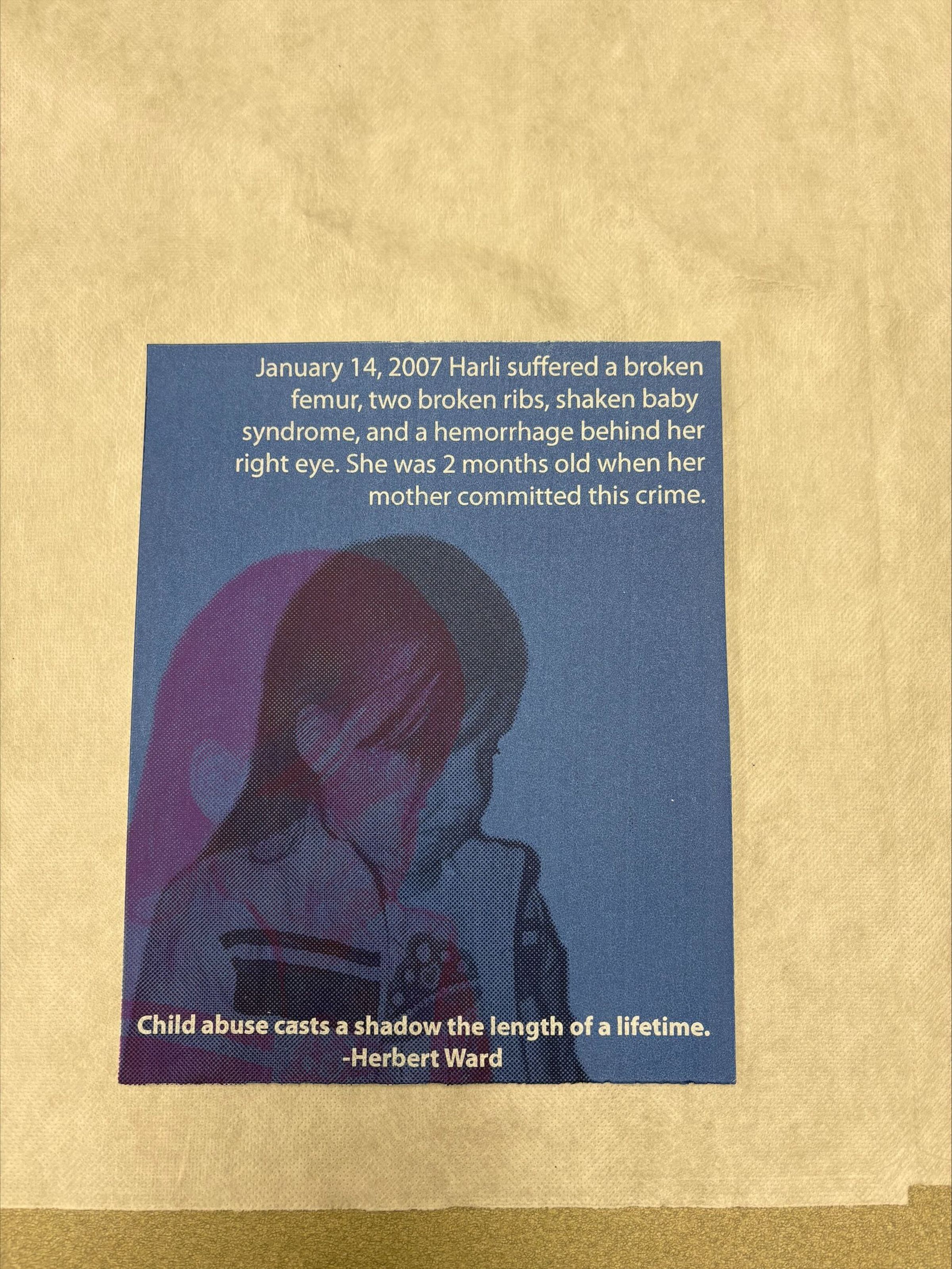 Front: A vertically oriented, medium sized print that is primarily blue with white text at the top and bottom of the print, along with the image of a child positioned between the text. The child is done in black with a purple overlay of the child on top of the primary image.