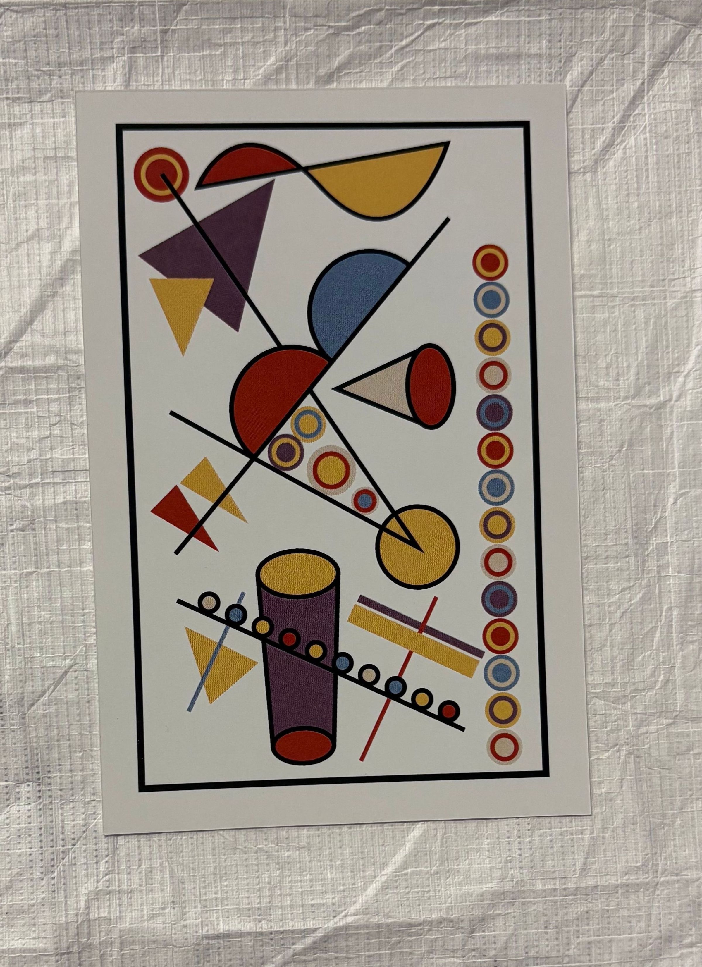 Front: A small, vertically oriented print that is done on a white colored ground and utilizes multiple colors. The print has no figural imagery and is composed of multiple geometric shapes that range from circles, semi-circles, triangles and lines. These shapes are surrounded by a thin, black rectangular border that encloses them in.