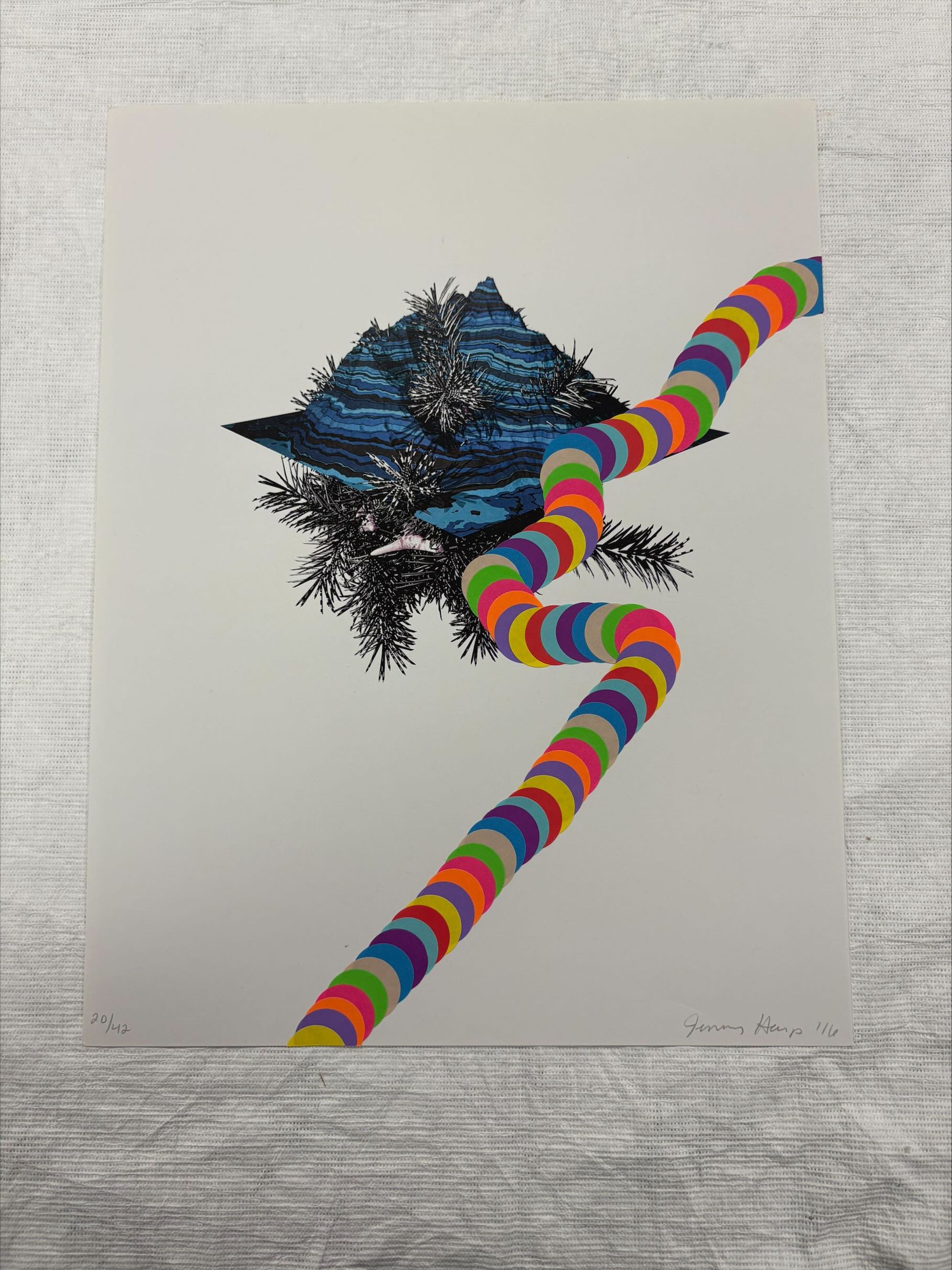 Front: A vertical oriented digital print done on standard letter sized paper. The print illustrates and organic segmental rock formation with a rainbow color trail consisting of stickers traveling in a moving line in front of the formation.