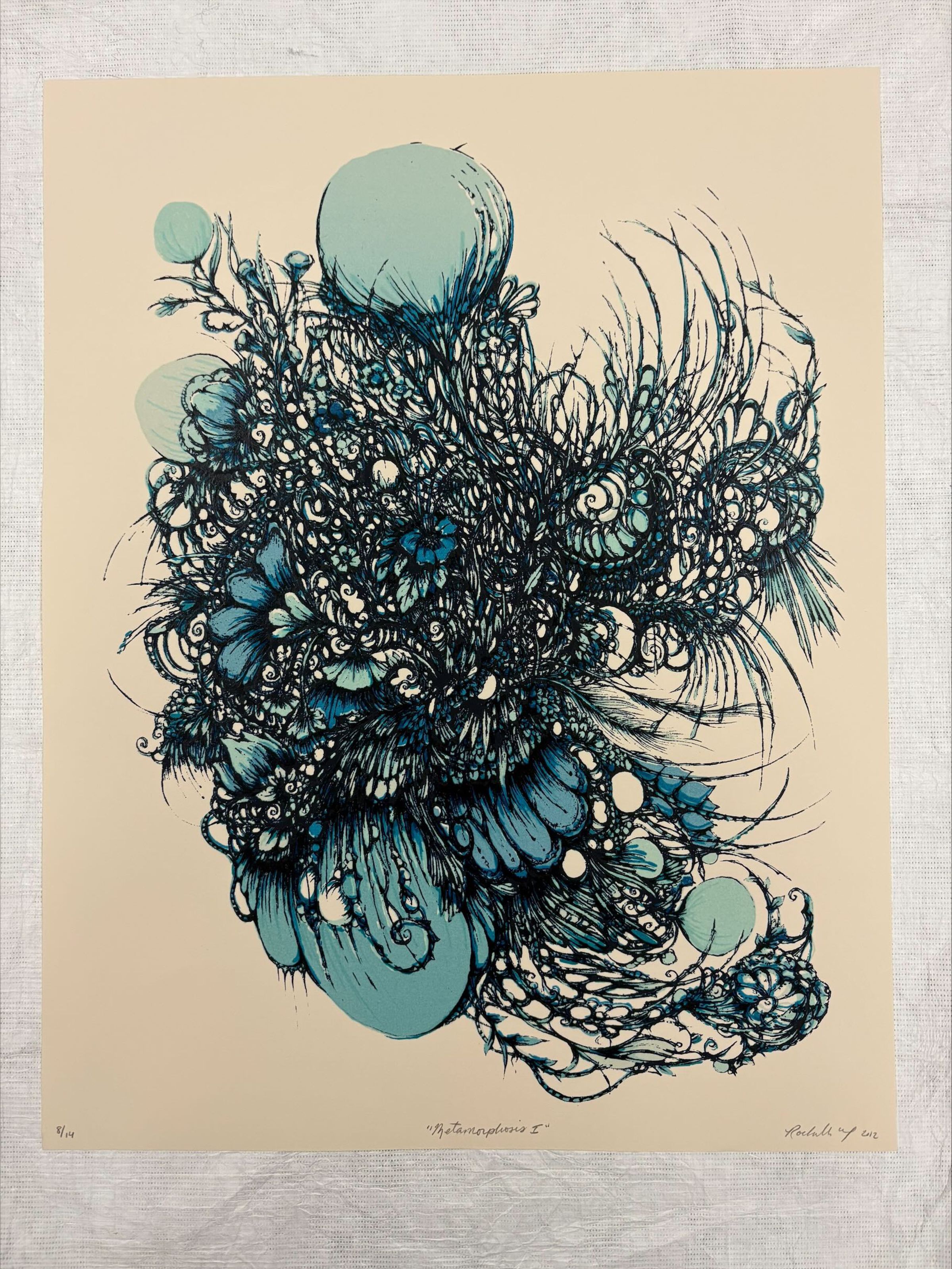 Front: A vertically oriented, medium sized print that is done on a cream ground with various shades of blue pigment creating the main forms of the work with black pigment used to add outlines and small details. The print is composed to look like an abstract and organic form that is an amalgamation of different flora and fauna found in nature.