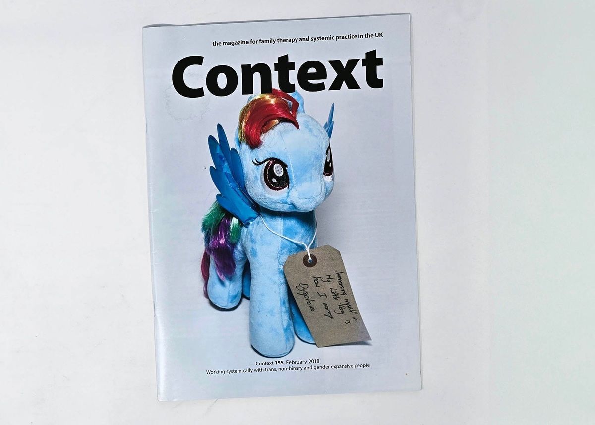 Copy of "Context" magazine with a white cover and a photo of a blue "Rainbow Dash" my little pony plush with a tag around its neck (MOT000102).